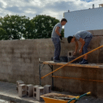 ALUMNOS DE ALBAÑILÉRIA CONSTRUYEN UN MURO CON BLOQUES DE CEMENTO COMO PARTE DE SU FORMACIÓN PRÁCTICA